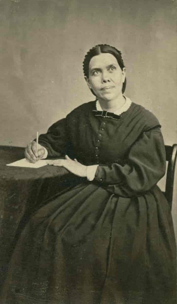 Author Ellen G White writing at her desk.