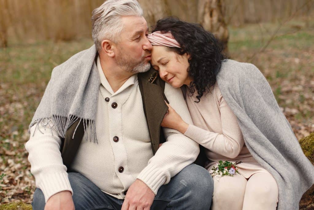 A married couple sets together embracing each other