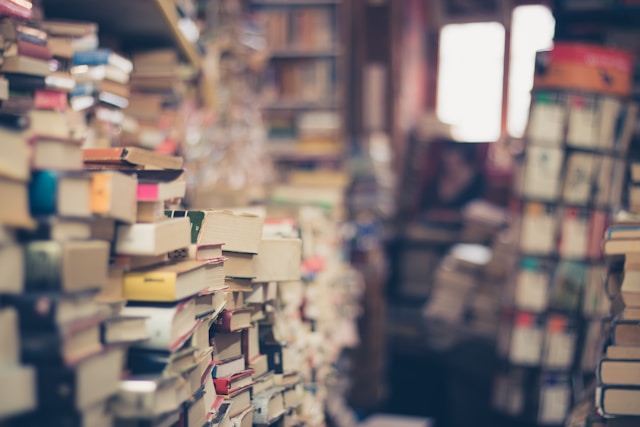 Stacks of books from the floor to the ceiling, messy and in need of organization