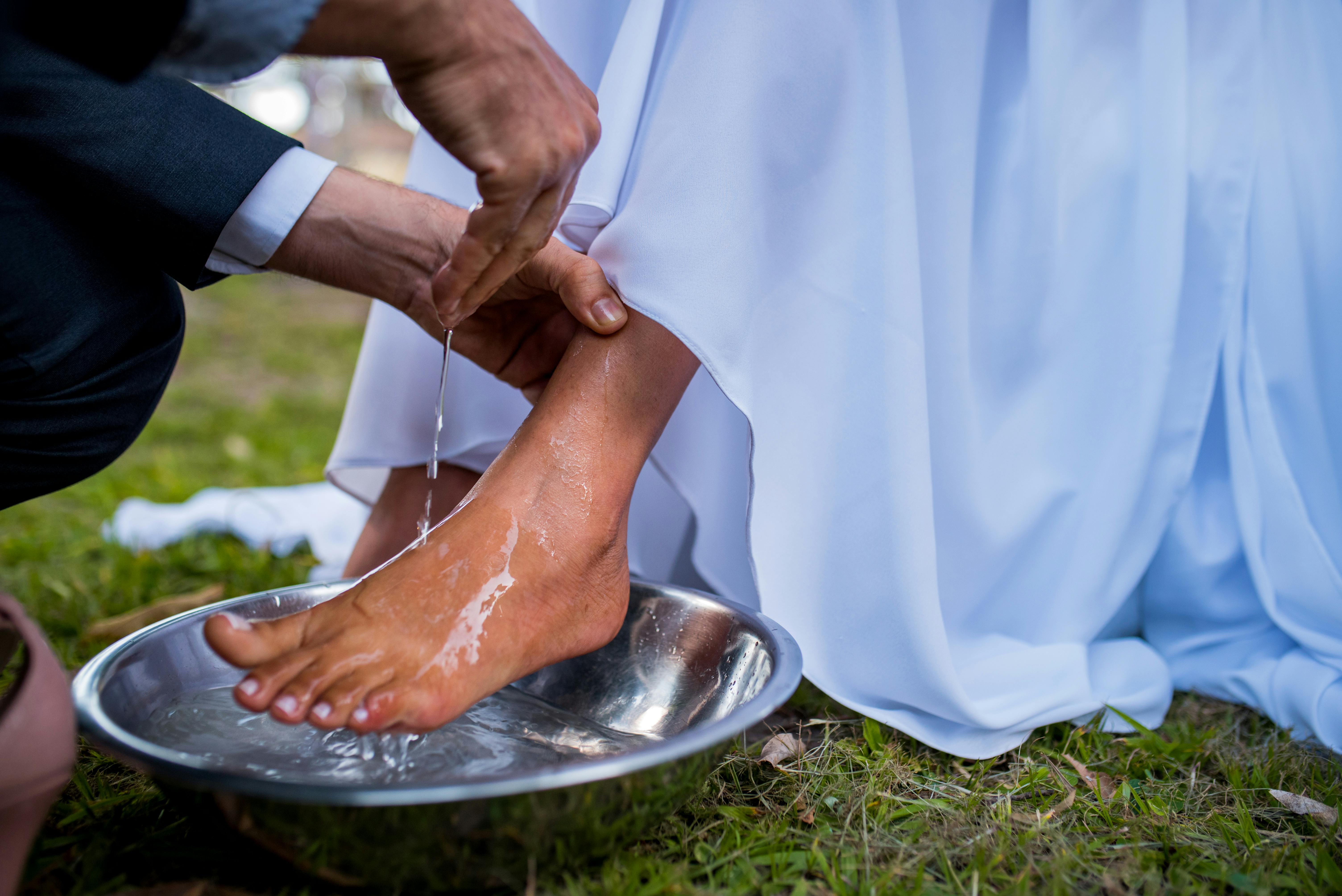 A husband washes his wife's feet in a basin of water, just as Jesus gave us an example to serve each other.