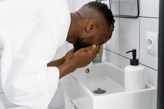 Man taking care of his personal hygiene and health by washing his face with soap and water