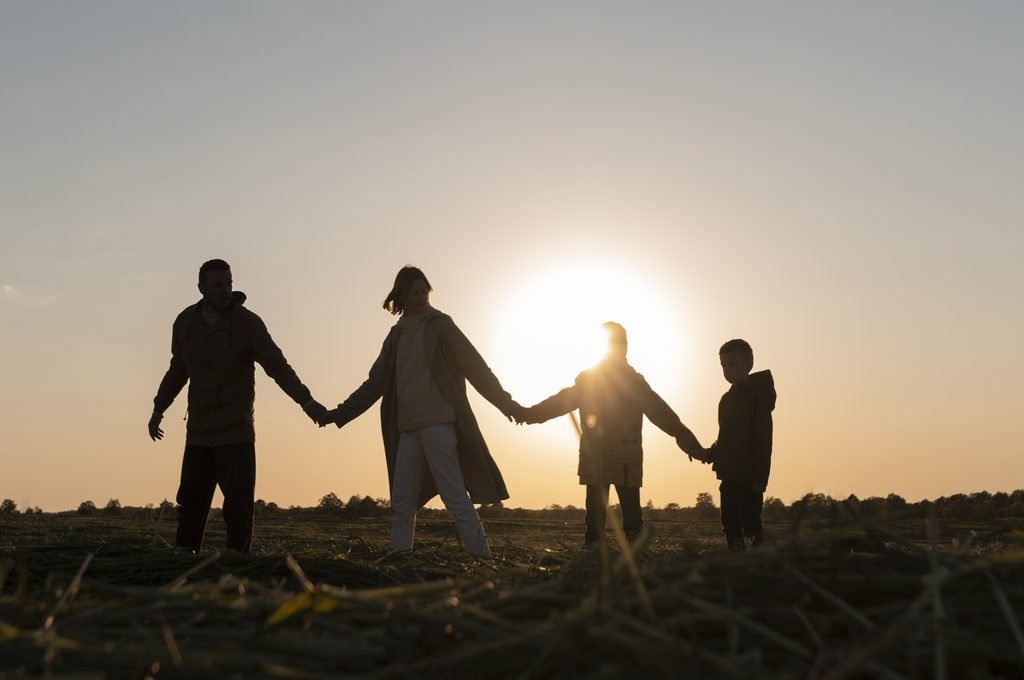 Full shot family silhouette having fun at sunset. Image by magnific